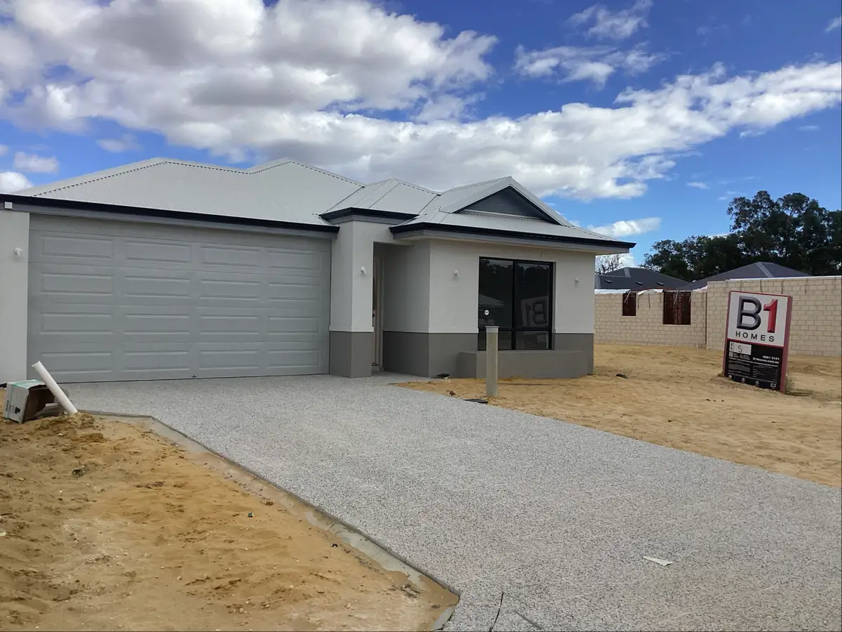 Newly constructed single-story home exterior with a paved driveway and B1 Homes sign.